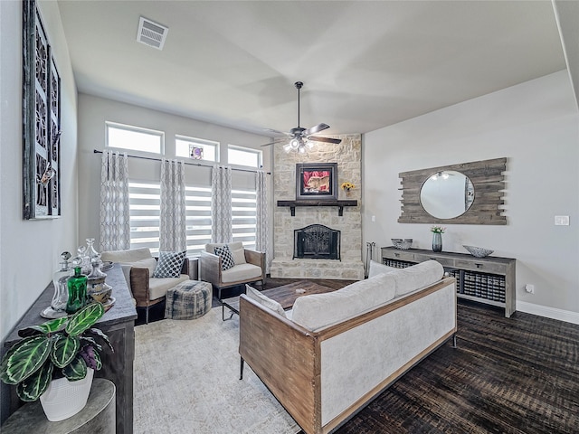 living room with ceiling fan and a stone fireplace