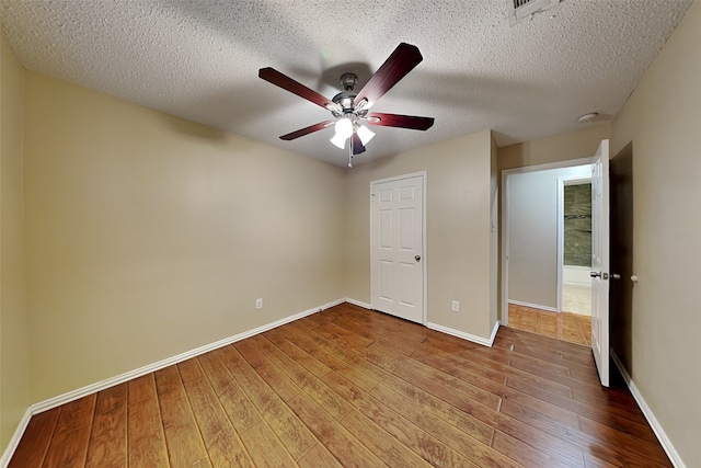 unfurnished bedroom with ceiling fan, hardwood / wood-style floors, and a textured ceiling