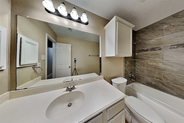 full bathroom featuring a textured ceiling, toilet, tiled shower / bath combo, and vanity