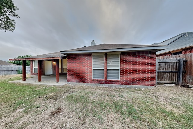 back of property with a patio area and a yard