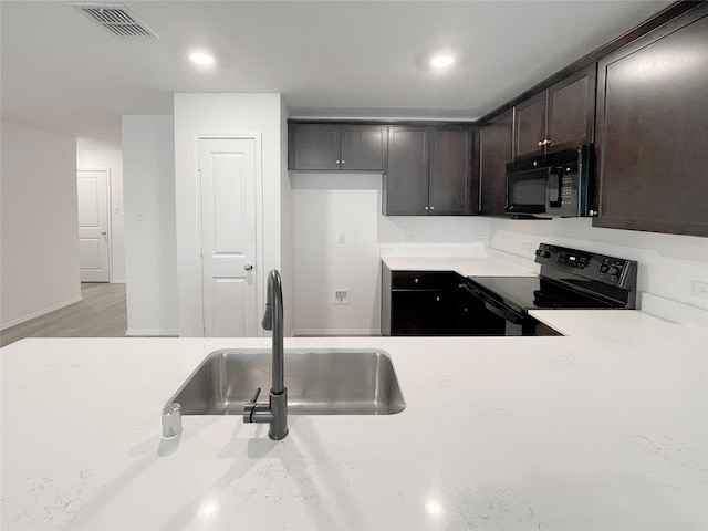 kitchen featuring light hardwood / wood-style floors, sink, dark brown cabinetry, and black appliances