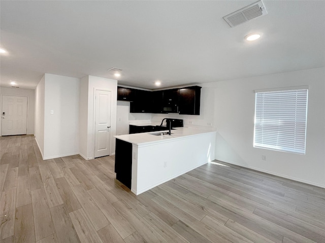 kitchen featuring light hardwood / wood-style floors, sink, and kitchen peninsula