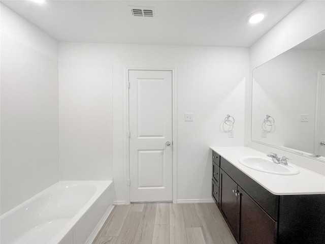 bathroom featuring a bathtub, wood-type flooring, and vanity