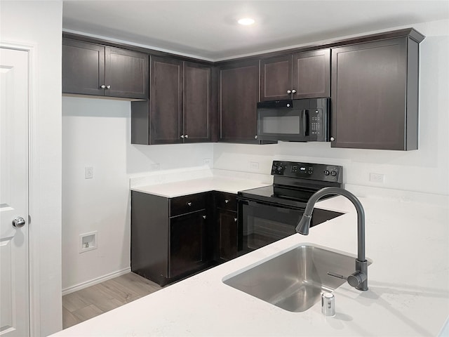 kitchen featuring sink, dark brown cabinets, light hardwood / wood-style flooring, and black appliances