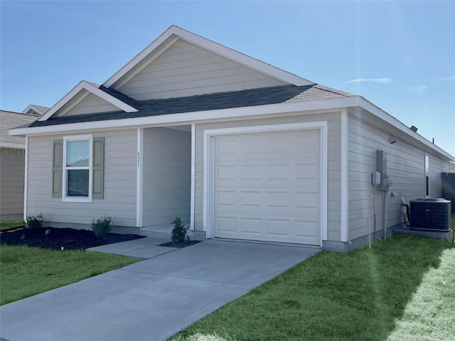 view of front of house featuring a front lawn, cooling unit, and a garage