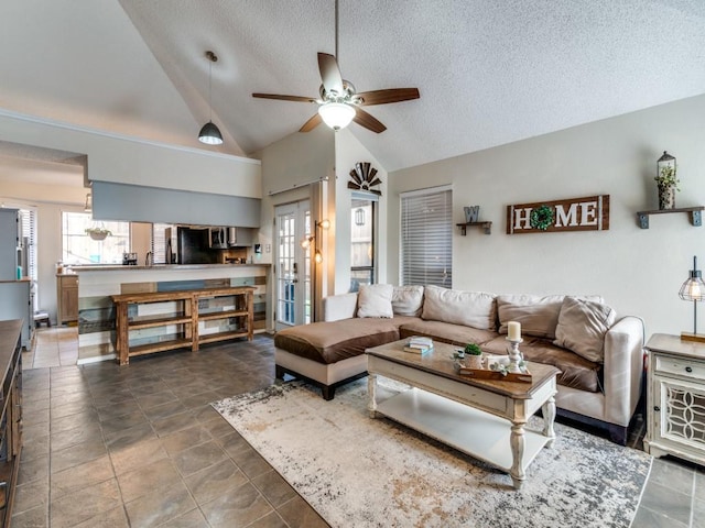 living room featuring ceiling fan, a textured ceiling, and vaulted ceiling