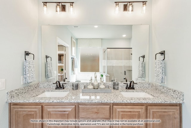 bathroom featuring a shower with shower door and vanity