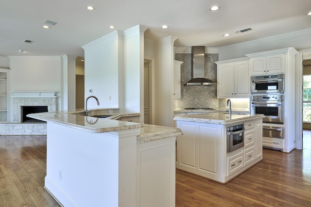 6601 Oak Hill Ct, Fort Worth, TX 76132 - kitchen with a kitchen island with sink, a sink, wall chimney exhaust hood, a warming drawer, and wood finished floors