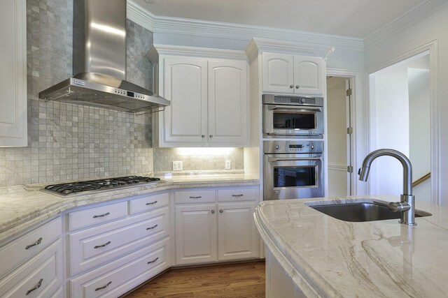 6601 Oak Hill Ct, Fort Worth, TX 76132 - kitchen featuring wall chimney range hood, a sink, appliances with stainless steel finishes, light stone counters, and white cabinets