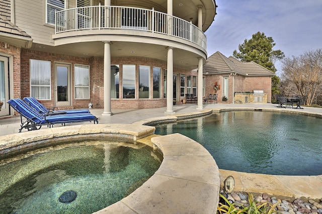 view of pool featuring a patio area and an in ground hot tub