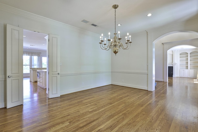 6601 Oak Hill Ct, Fort Worth, TX 76132 - unfurnished room with wood finished floors, arched walkways, crown molding, a chandelier, and recessed lighting