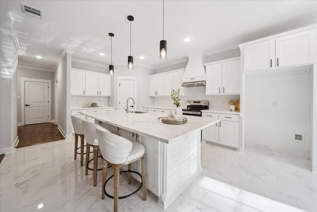 kitchen featuring a center island with sink, stainless steel electric stove, white cabinets, and custom range hood