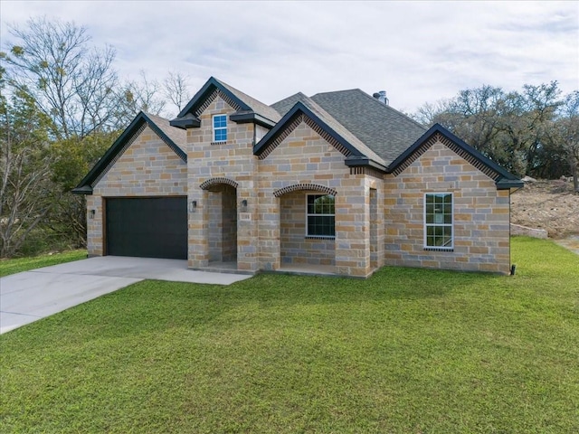 view of front of property featuring a front yard and a garage