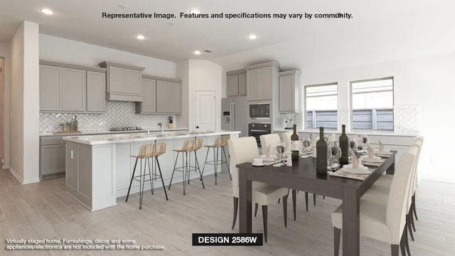 kitchen with black appliances, gray cabinets, and a center island with sink