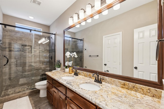 bathroom with toilet, a shower with door, wood-type flooring, and vanity