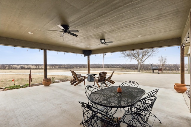 view of patio with ceiling fan and a rural view