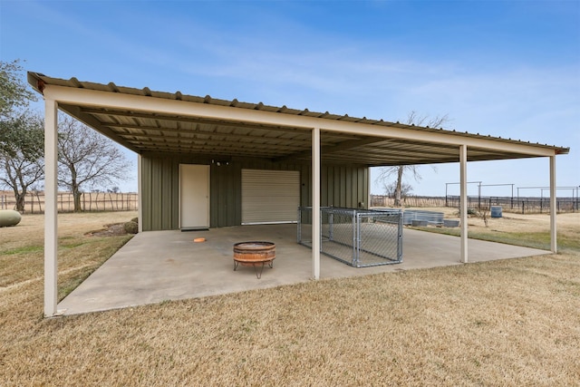 view of patio / terrace with an outdoor fire pit and an outbuilding