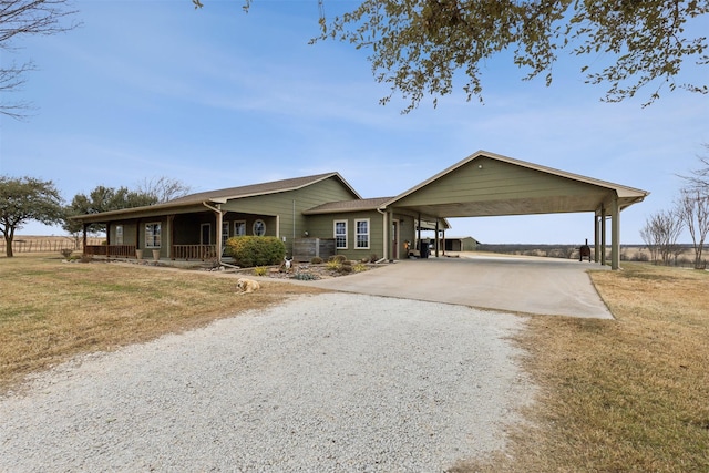 ranch-style house with a front lawn, a carport, and a porch