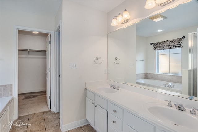 bathroom featuring vanity, tile patterned floors, and a bath