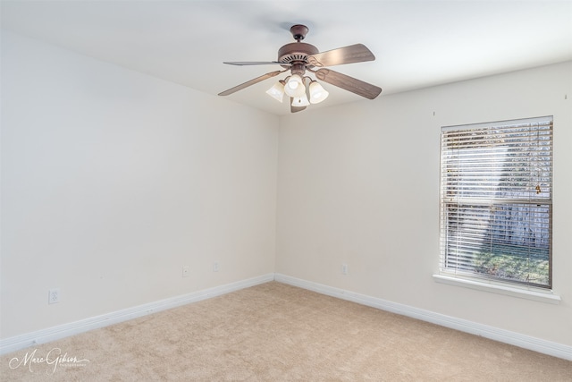 spare room with ceiling fan, a healthy amount of sunlight, and light colored carpet