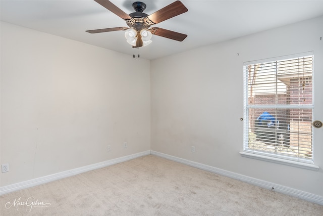 carpeted spare room featuring ceiling fan and plenty of natural light