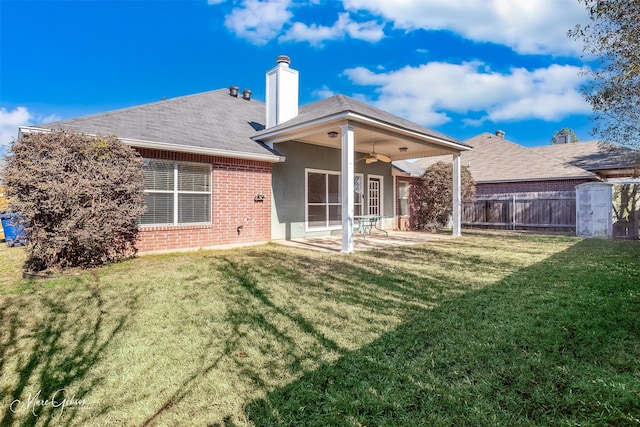 back of house featuring ceiling fan, a yard, and a patio