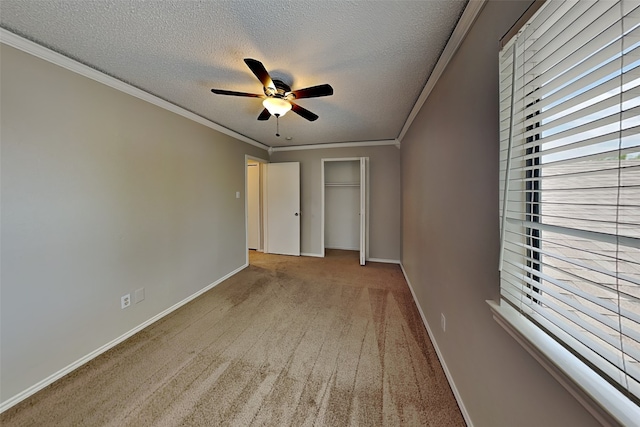 unfurnished bedroom with light carpet, ceiling fan, a closet, a textured ceiling, and crown molding