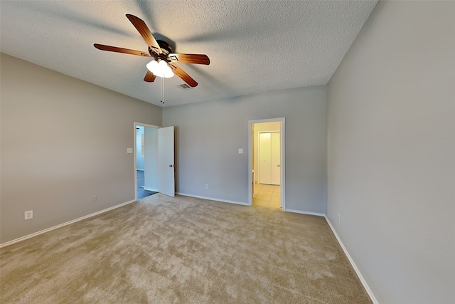 unfurnished bedroom featuring a textured ceiling, ceiling fan, and light colored carpet