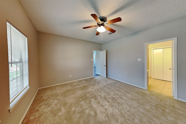 carpeted empty room featuring ceiling fan and a textured ceiling