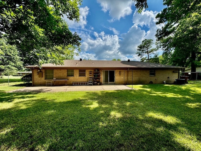 rear view of property with a lawn and a patio