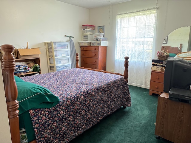 bedroom with a textured ceiling and dark carpet