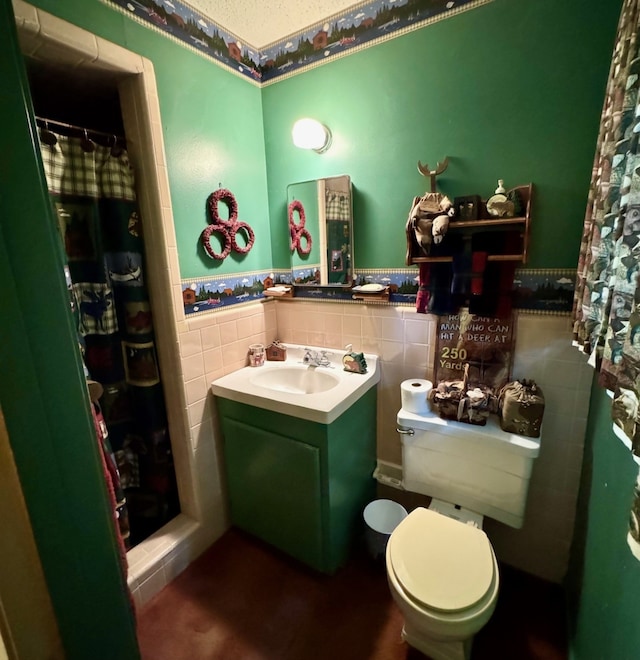 bathroom featuring toilet, a shower with shower curtain, tile walls, and vanity