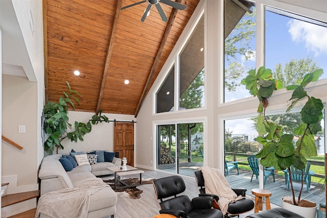 living room featuring ceiling fan, a barn door, beam ceiling, wood ceiling, and high vaulted ceiling