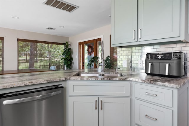 kitchen featuring sink, white cabinetry, dishwasher, and tasteful backsplash