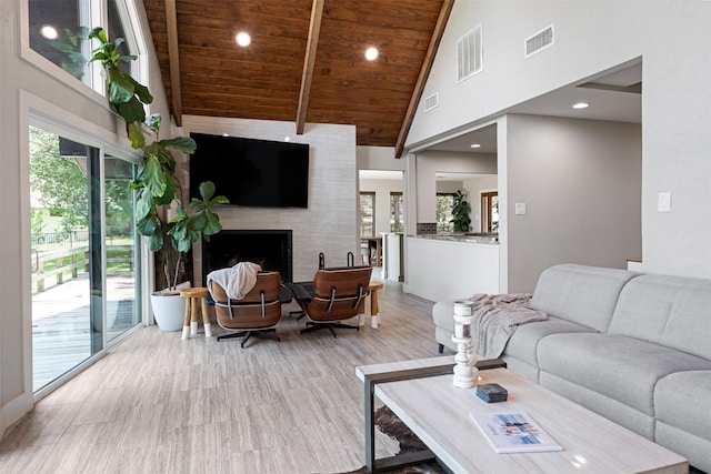 living room featuring beamed ceiling, a large fireplace, wood ceiling, and high vaulted ceiling