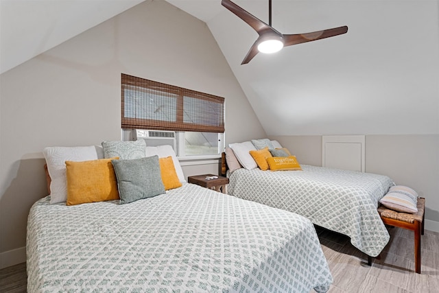 bedroom featuring ceiling fan, light hardwood / wood-style flooring, vaulted ceiling, and cooling unit