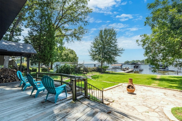 wooden deck with a water view, a lawn, and a patio