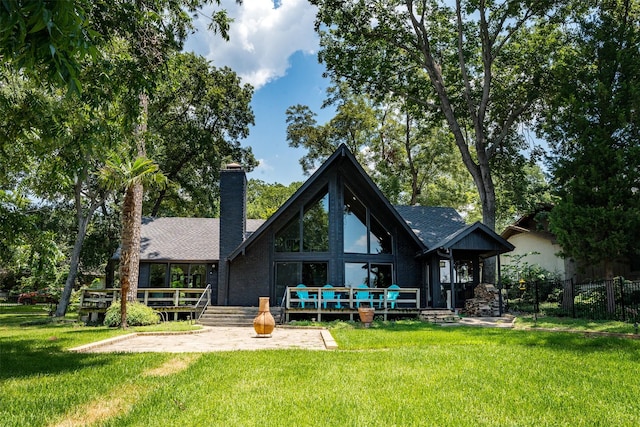 back of property with a wooden deck and a lawn