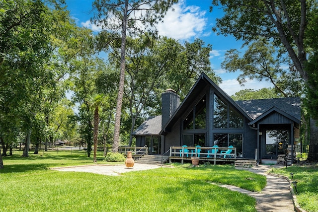 rear view of house featuring a patio area, a deck, and a lawn