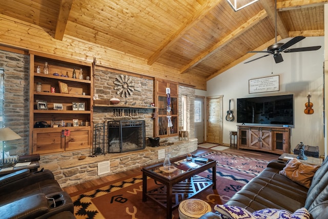 living room with beam ceiling, wood-type flooring, wood ceiling, a stone fireplace, and high vaulted ceiling