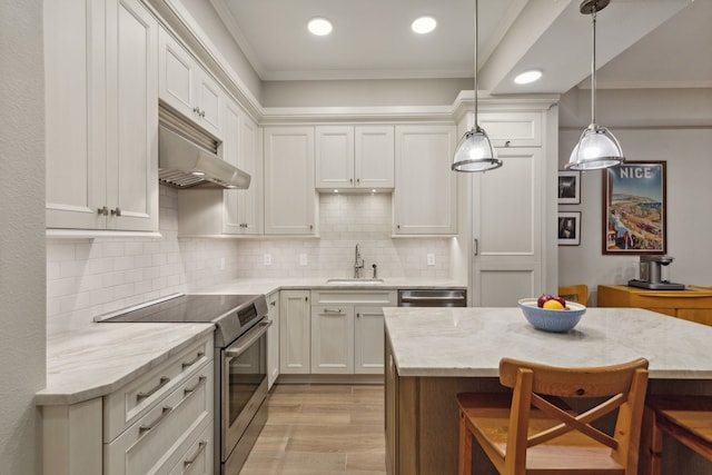 kitchen featuring light stone countertops, appliances with stainless steel finishes, a breakfast bar area, and ornamental molding