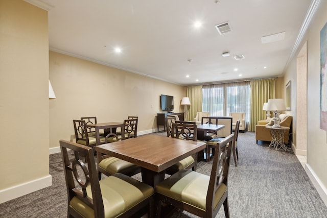 dining room with dark carpet and ornamental molding