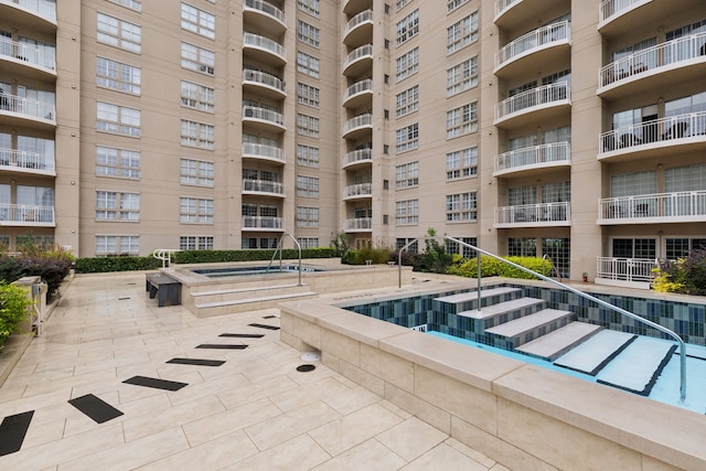 view of swimming pool with a hot tub and a patio