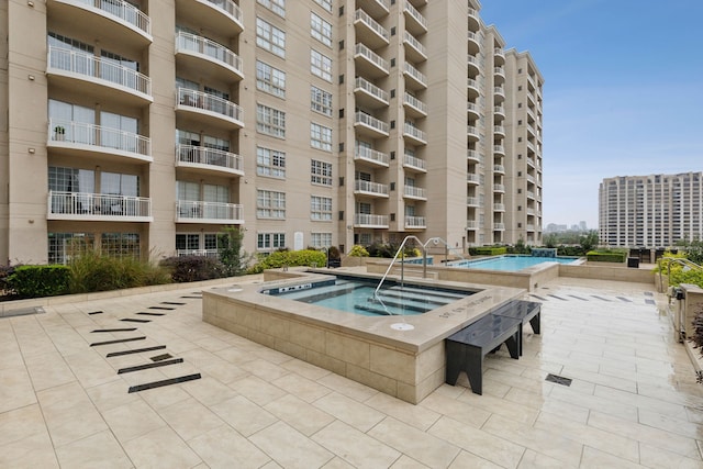 view of swimming pool featuring a patio area and a hot tub