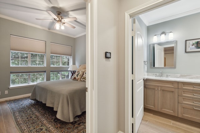 bedroom with ceiling fan, ensuite bath, light wood-type flooring, crown molding, and sink