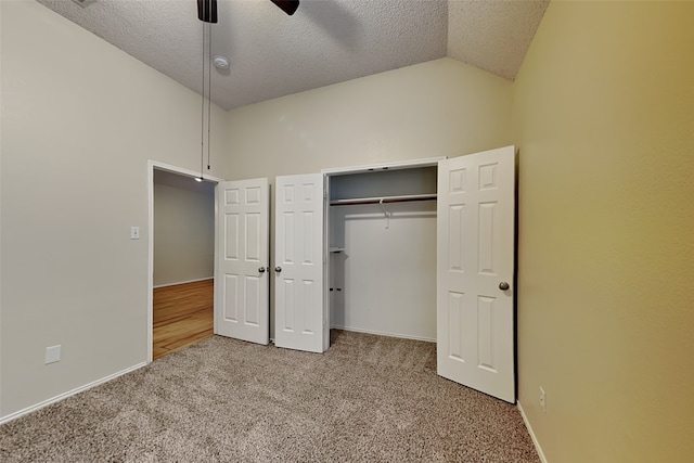 unfurnished bedroom with ceiling fan, a textured ceiling, a closet, and carpet flooring