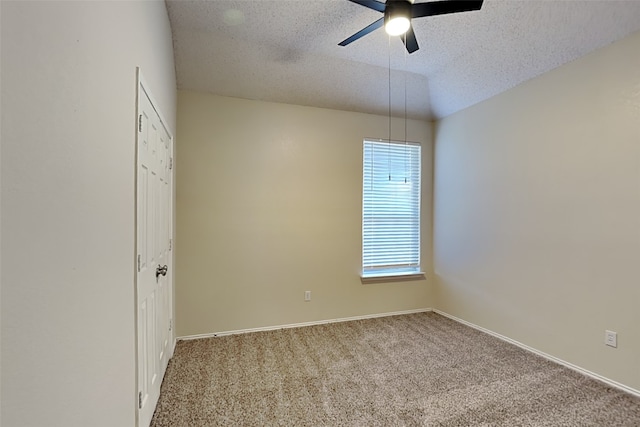 empty room with a textured ceiling, ceiling fan, carpet, and vaulted ceiling