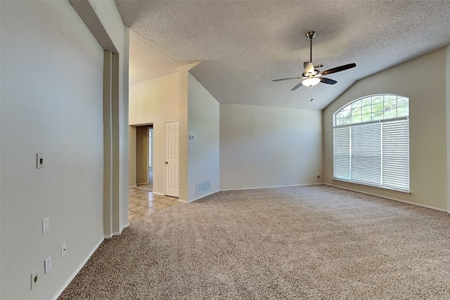 empty room featuring light carpet, vaulted ceiling, a textured ceiling, and ceiling fan