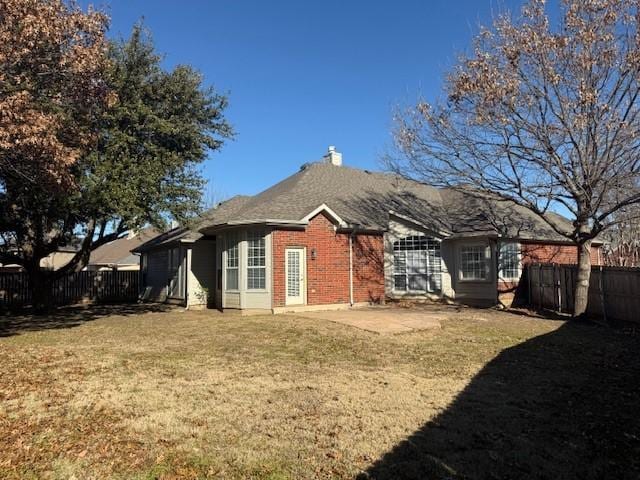 back of property with a yard and a patio