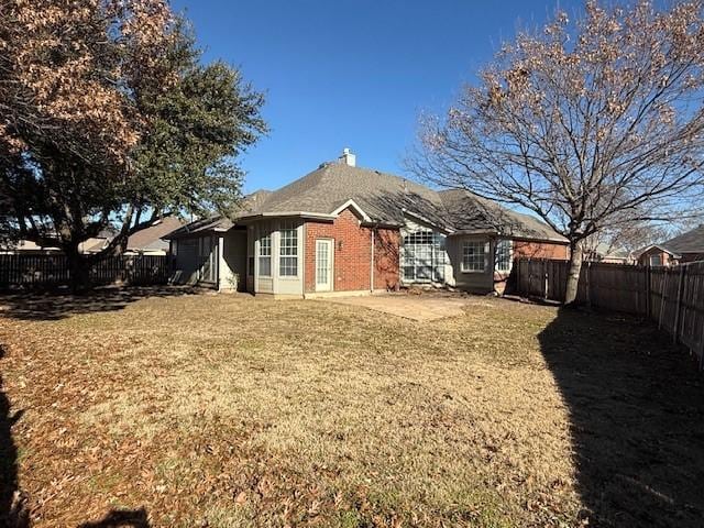 rear view of property with a yard and a patio